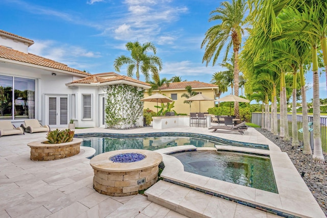 view of pool with an in ground hot tub, french doors, a fire pit, and a patio area