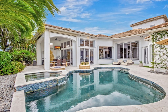 back of property featuring a swimming pool with hot tub, ceiling fan, and a patio area