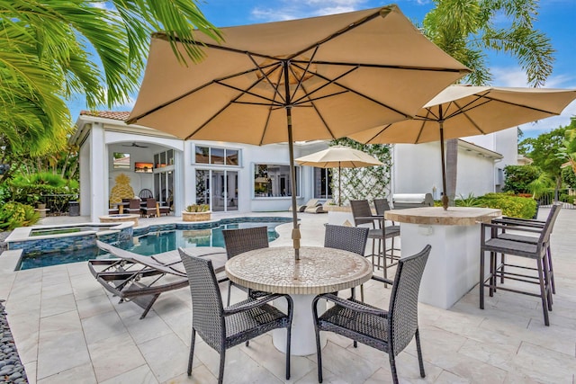 view of pool featuring an in ground hot tub, a patio, an outdoor bar, and ceiling fan