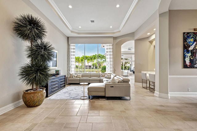 living room featuring a raised ceiling and ornamental molding