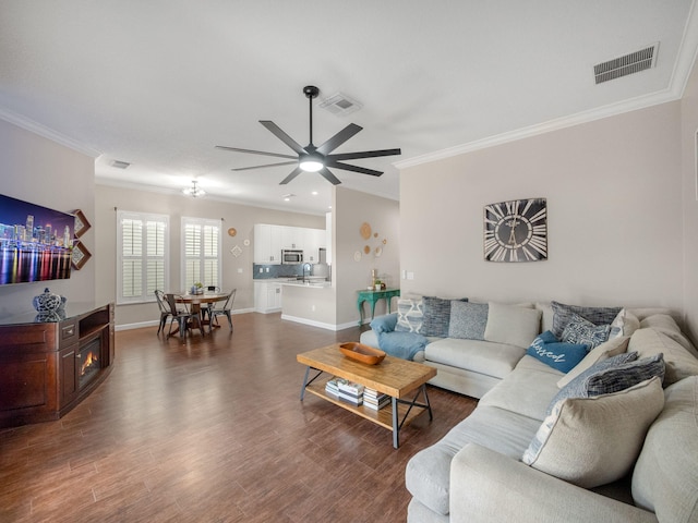 living room with ceiling fan, dark hardwood / wood-style flooring, and crown molding