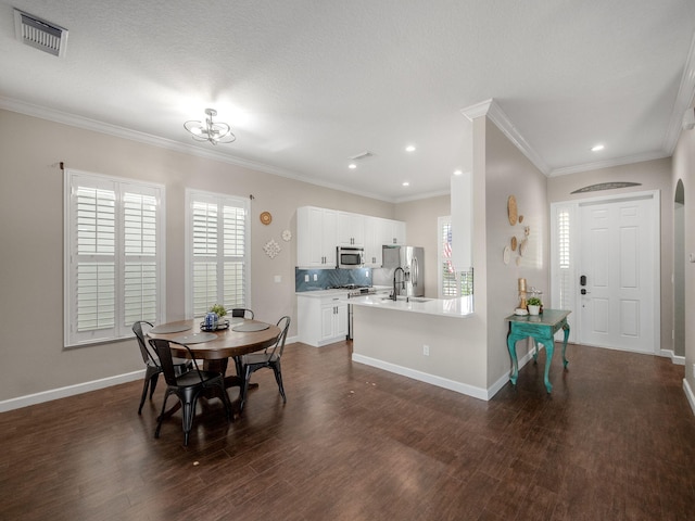 dining area featuring crown molding, dark hardwood / wood-style flooring, and a textured ceiling