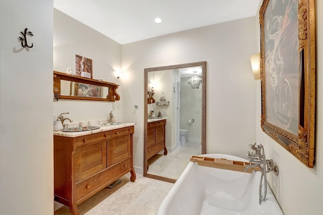 bathroom with vanity, a bath, and toilet