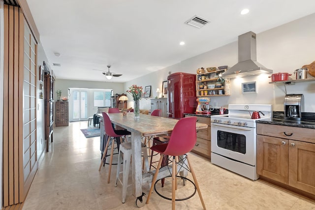 kitchen featuring white stove, island range hood, and ceiling fan