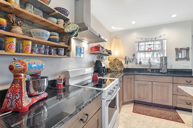 kitchen with sink, high end range, dark stone counters, and wall chimney range hood