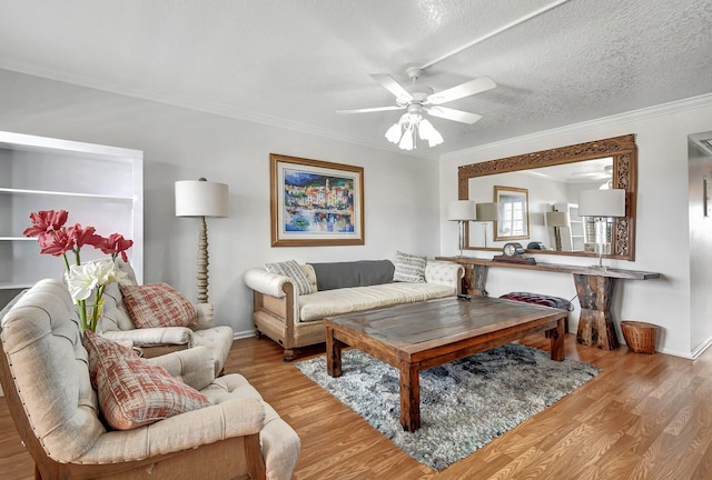 living room featuring light wood-style floors, ornamental molding, and a textured ceiling