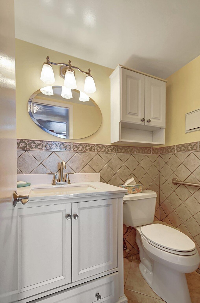 bathroom featuring tile patterned flooring, vanity, toilet, and tile walls