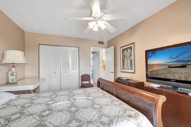 bedroom with ceiling fan, a textured ceiling, and a closet