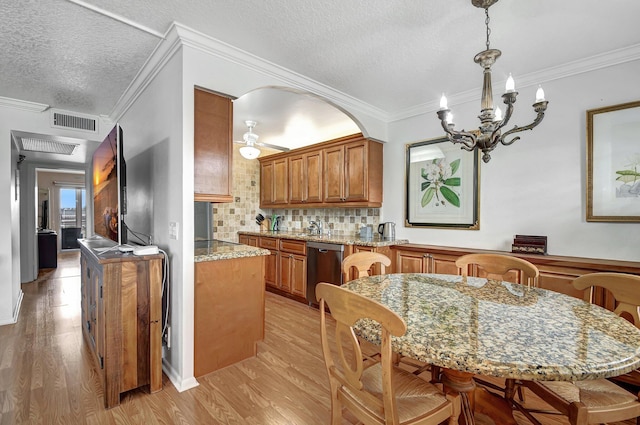 kitchen featuring dishwasher, light stone counters, light hardwood / wood-style flooring, crown molding, and pendant lighting