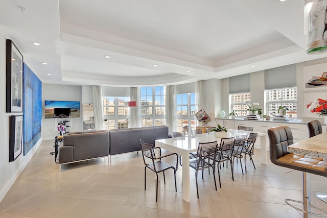 tiled dining area featuring a tray ceiling