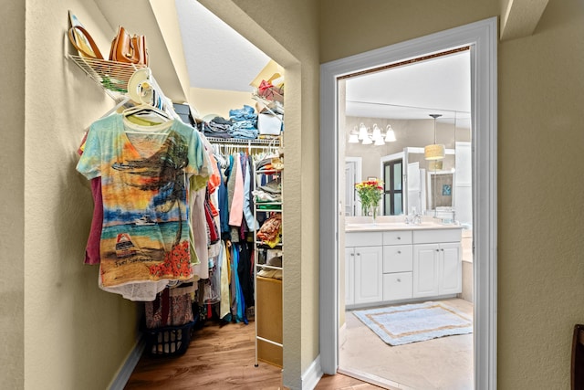 spacious closet featuring sink and light wood-type flooring