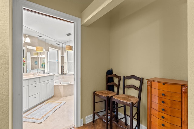 bathroom with hardwood / wood-style floors, a bathtub, and vanity