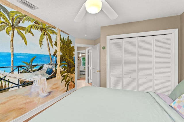 bedroom featuring access to outside, a textured ceiling, a closet, and ceiling fan