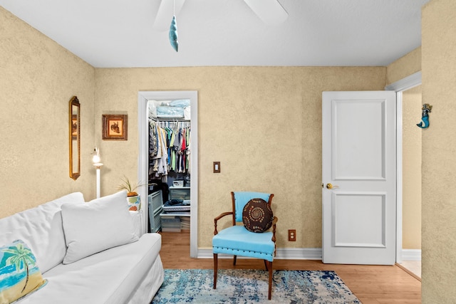 living area featuring ceiling fan and hardwood / wood-style flooring