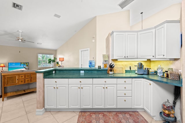 kitchen featuring light tile patterned floors, white cabinets, and vaulted ceiling