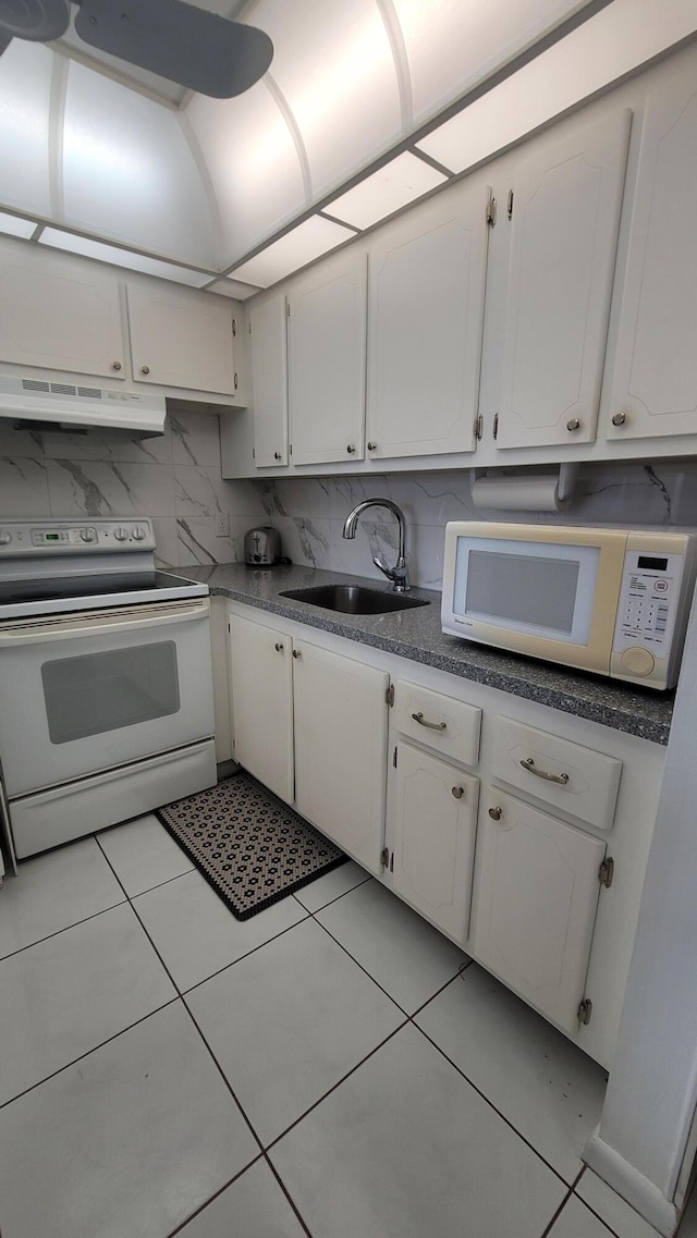 kitchen featuring white cabinetry, light tile patterned flooring, white appliances, and sink