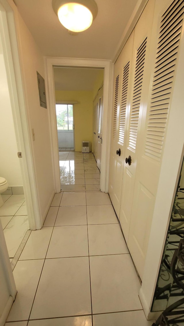 corridor with electric panel and light tile patterned floors