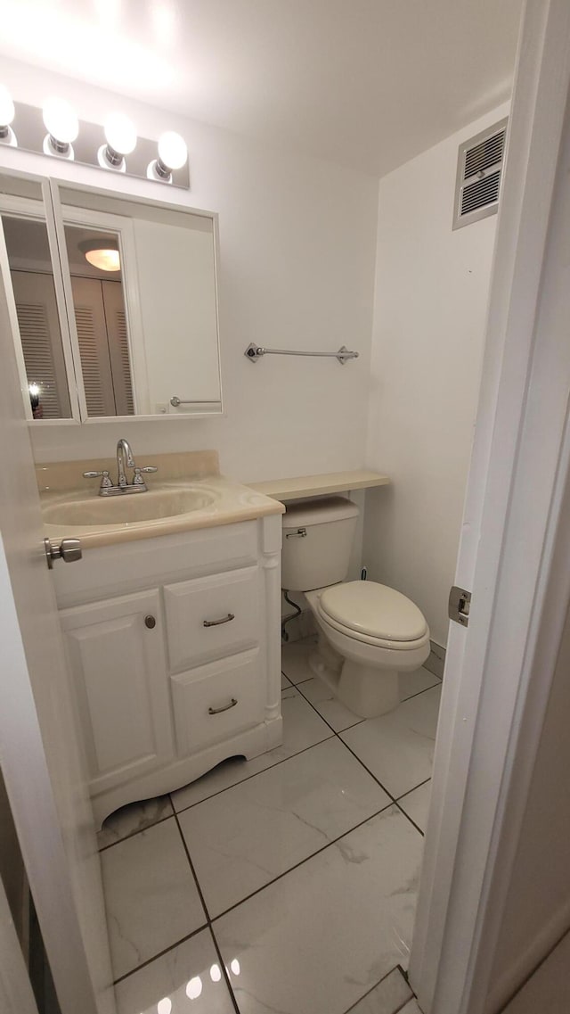 bathroom featuring tile patterned floors, vanity, and toilet