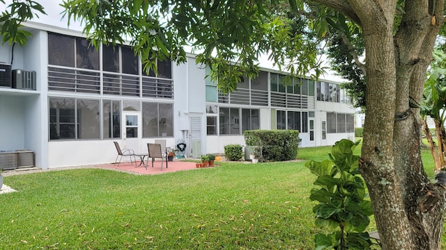 rear view of house featuring a yard and a patio area