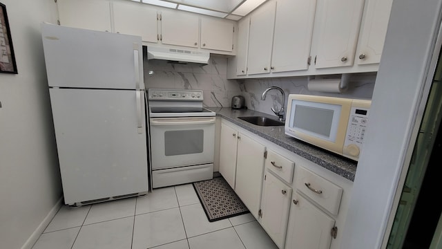 kitchen with white appliances, sink, decorative backsplash, light tile patterned floors, and white cabinetry