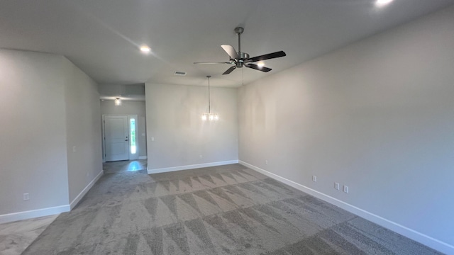 empty room featuring light carpet and ceiling fan with notable chandelier