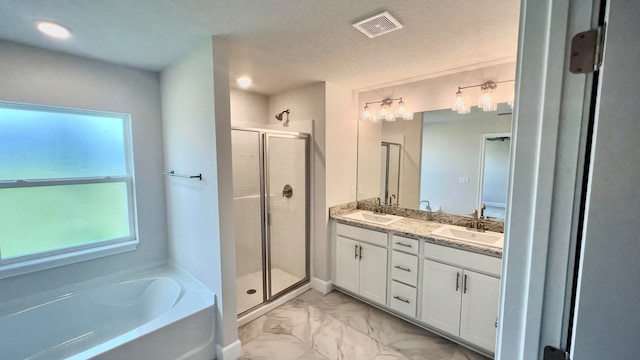 bathroom featuring a textured ceiling, vanity, and independent shower and bath