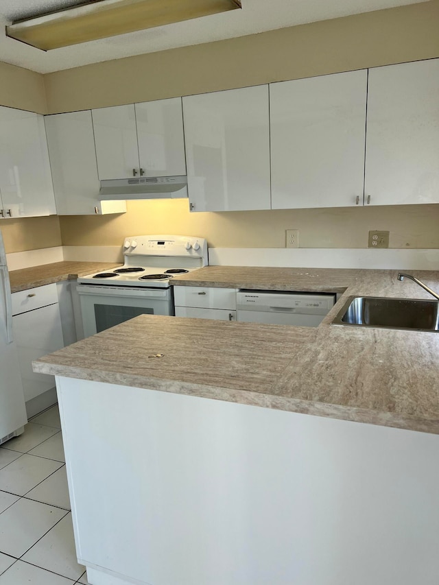 kitchen featuring white cabinets, white appliances, light tile patterned flooring, and sink