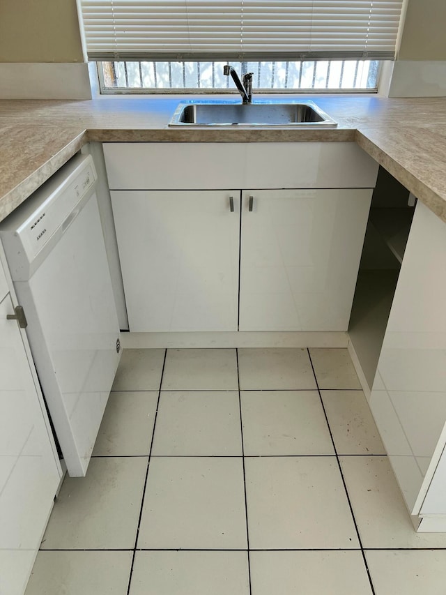 kitchen featuring dishwasher, light tile patterned floors, white cabinetry, and sink