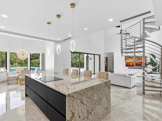 kitchen with white cabinetry, tasteful backsplash, decorative light fixtures, a breakfast bar area, and black appliances