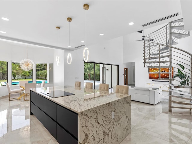 kitchen with visible vents, a high ceiling, marble finish floor, modern cabinets, and black electric cooktop