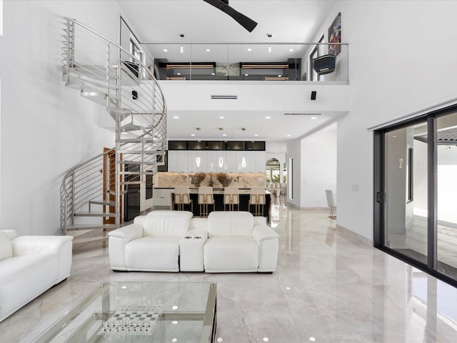 living room with a towering ceiling and ceiling fan