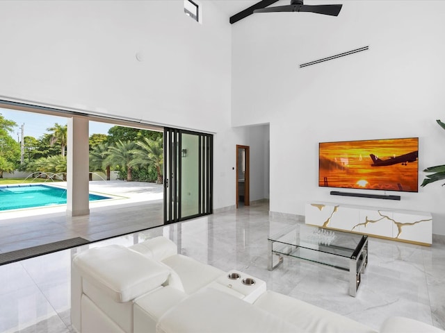 living room with visible vents, marble finish floor, a ceiling fan, and a towering ceiling