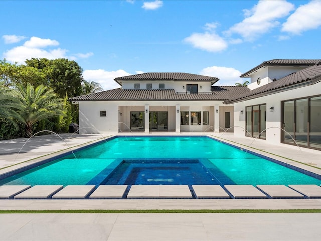 view of swimming pool with a patio and a pool with connected hot tub