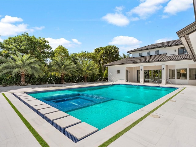 view of swimming pool featuring a pool with connected hot tub and a patio area