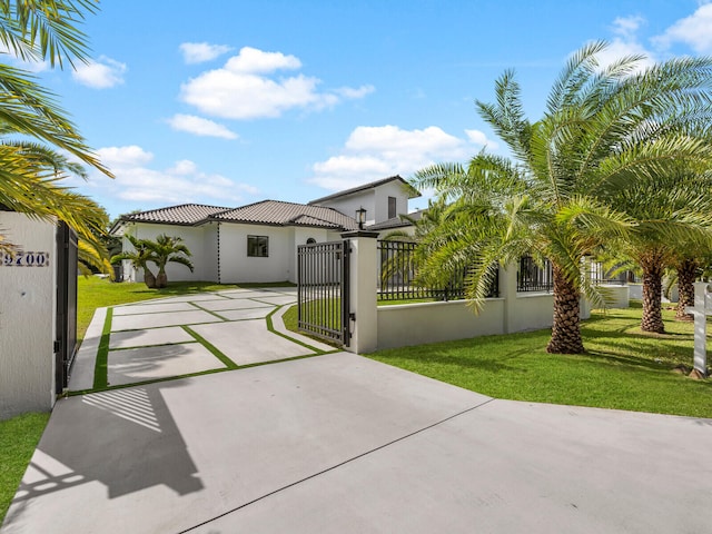 exterior space with stucco siding, a front lawn, a gate, a fenced front yard, and concrete driveway