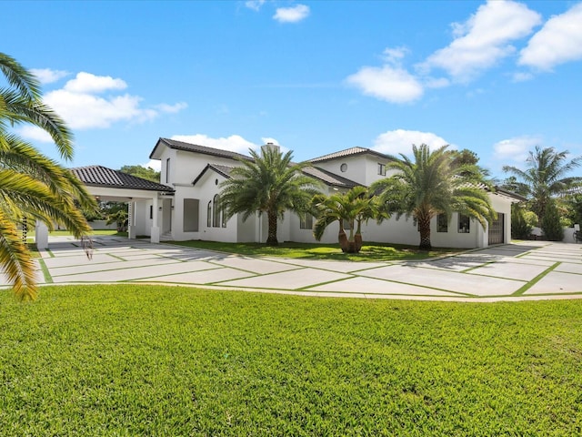 exterior space with concrete driveway, an attached garage, a lawn, and stucco siding