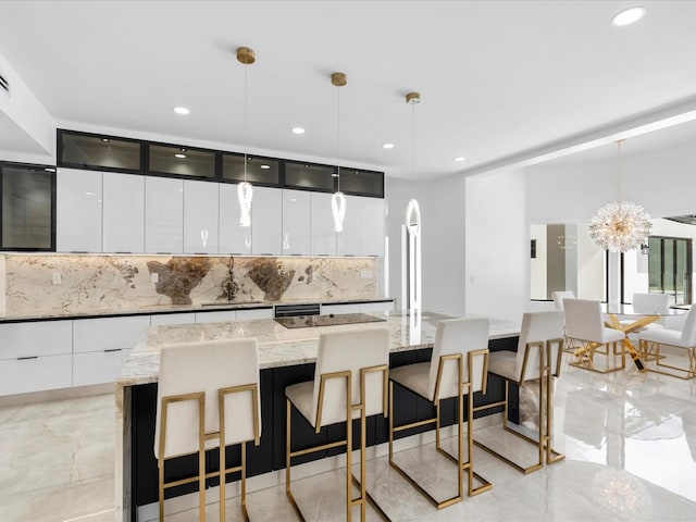 kitchen with white cabinetry, a center island, backsplash, pendant lighting, and a kitchen bar