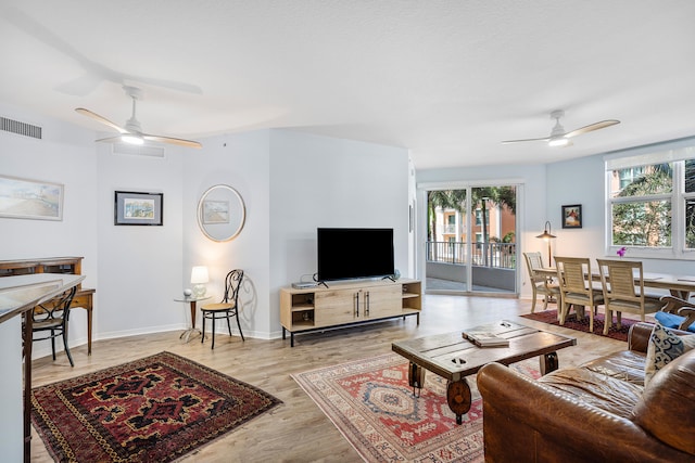 living room featuring light hardwood / wood-style flooring and ceiling fan