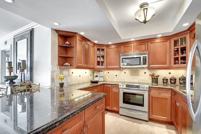 kitchen with dark stone countertops, decorative backsplash, stainless steel appliances, and ornamental molding