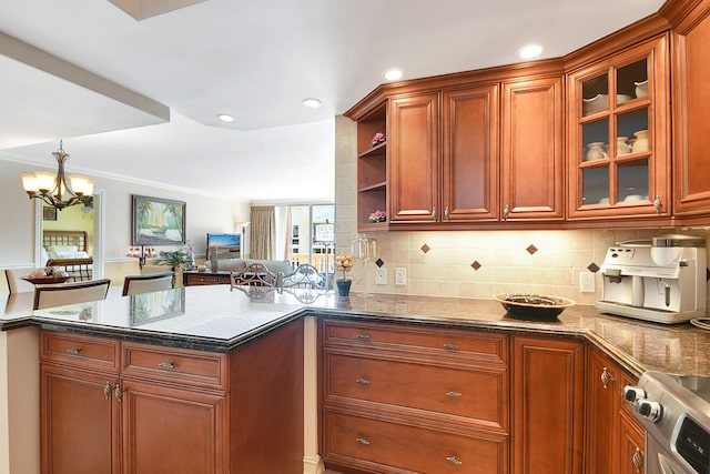 kitchen with stainless steel range, crown molding, dark stone counters, pendant lighting, and decorative backsplash