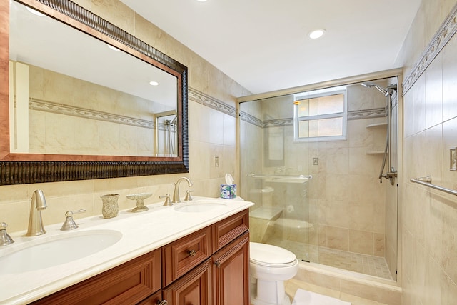 bathroom featuring vanity, toilet, walk in shower, and tile walls