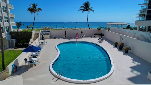 view of swimming pool with a water view and a patio