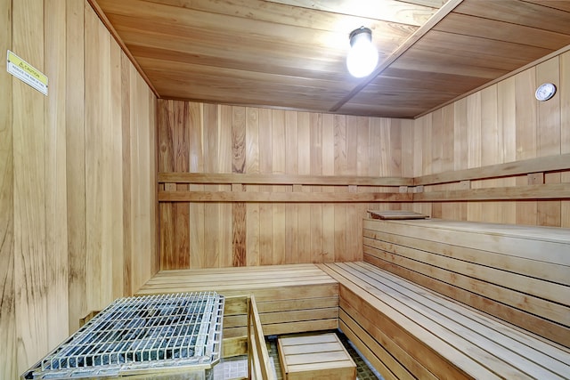 view of sauna with wooden ceiling and wooden walls