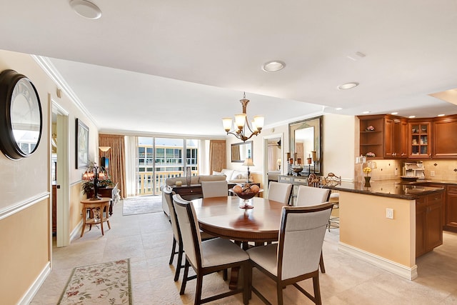 dining room featuring crown molding, light tile patterned floors, and a chandelier