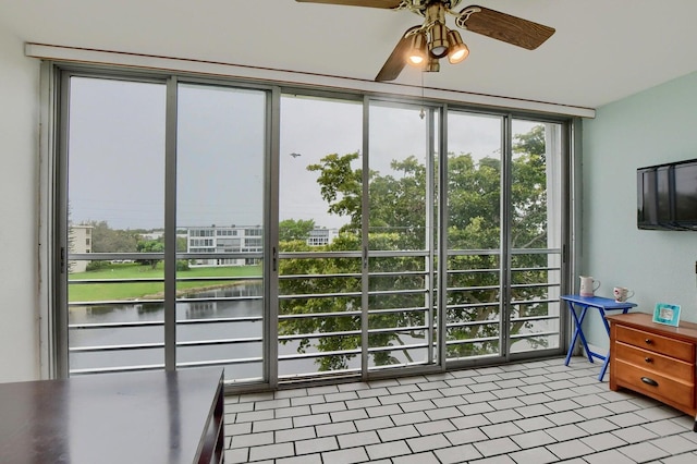 entryway featuring ceiling fan, a water view, light tile patterned floors, and a wall of windows