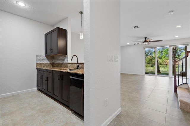 kitchen featuring sink, decorative light fixtures, stainless steel dishwasher, light stone countertops, and dark brown cabinets