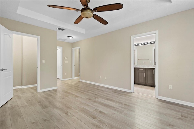 unfurnished bedroom with ensuite bathroom, light hardwood / wood-style flooring, and ceiling fan