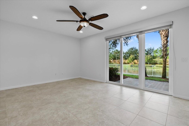 spare room with ceiling fan and light tile patterned floors