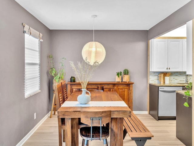 dining space featuring plenty of natural light, baseboards, and light wood-style floors