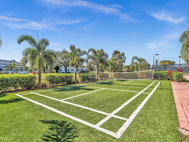 view of property's community with a tennis court and fence